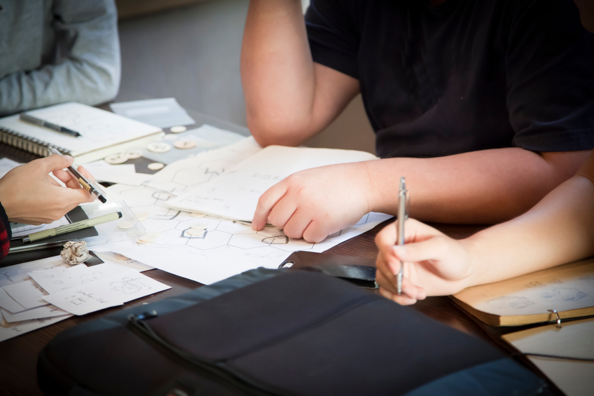 Group of people working together on a project with books and diagrams